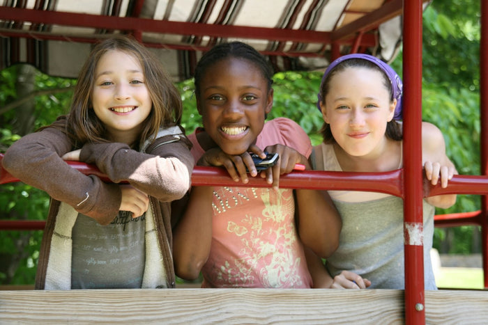 drei kinder lachend auf spielgerät als collage bild mit bedeutung freundschaft verbindung und gemeinsames spiel
