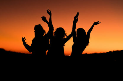 silhouet van mensen met opgeheven armen tegen zonsondergang als collage afbeelding met betekenis emotie vrijheid en expressie