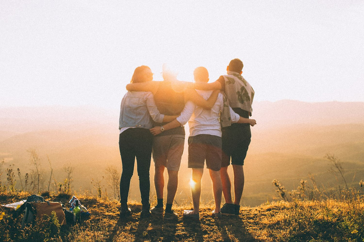 groep mensen met armen om elkaar bij zonsondergang als collage afbeelding met betekenis verbinding relaties en steun